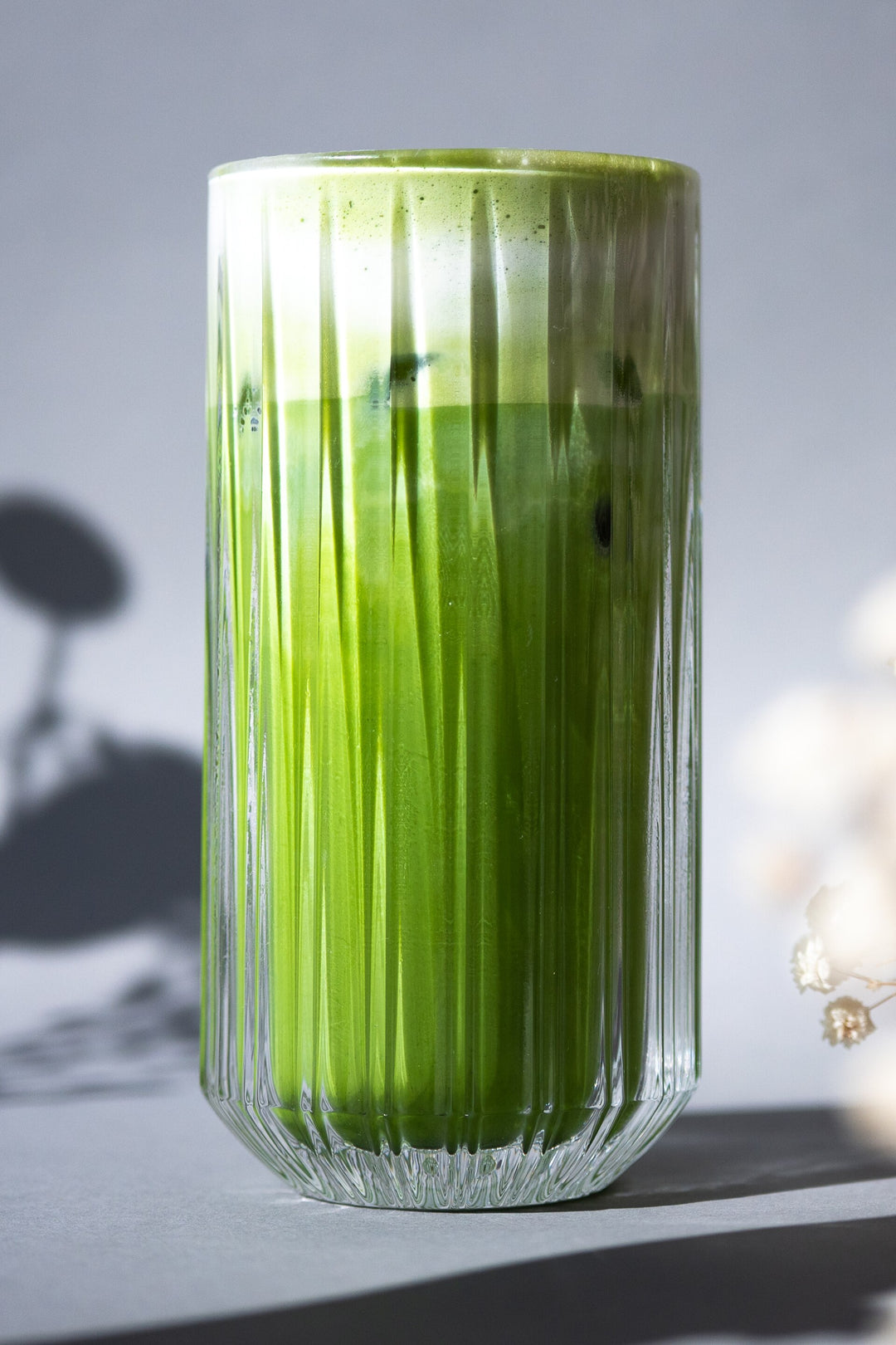 Iced matcha latte in a tall ribbed glass